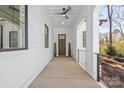 Covered front porch, features include a ceiling fan, recessed lights, and a dark wood front door at 3953 Plainview Rd, Charlotte, NC 28208