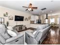 Cozy living room featuring hardwood floors, a ceiling fan, and comfortable gray reclining sofas at 4708 Chantress Ln, Monroe, NC 28110