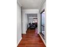 Inviting hallway with sleek hardwood floors leading to a cozy living area with plush recliners at 4715 Cricklewood Ln, Charlotte, NC 28212