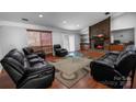 Spacious living room featuring a stone fireplace, hardwood floors, and comfortable leather seating at 4715 Cricklewood Ln, Charlotte, NC 28212