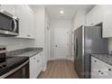Modern kitchen featuring stainless steel appliances, granite counters, and ample cabinet space at 5712 Skinny Ln, Charlotte, NC 28215