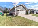 Home with a large two-car garage, driveway, and manicured lawn with garden at 7316 Strawberry Fields Ln, Charlotte, NC 28278