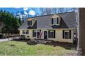 Charming home with dormer windows, a cozy front porch, and a wooden deck, all surrounded by lush greenery at 7648 Forest Oak Dr, Denver, NC 28037