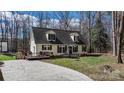 A charming home with a welcoming front porch and a spacious driveway leading to a wooden deck at 7648 Forest Oak Dr, Denver, NC 28037