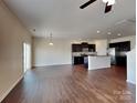 Open-concept living room and kitchen area with hardwood floors and modern appliances at 8906 Paddle Oak Rd, Charlotte, NC 28227