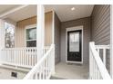 View of the cozy front porch with white railings, a black front door, and a small window at 8915 Myra Way # 39, Charlotte, NC 28215