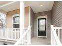 A closeup of the front porch with a black front door and a window on the beige-colored siding at 8915 Myra Way # 39, Charlotte, NC 28215