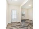 A bright, open living room with neutral walls and wood-look flooring and a white front door at 8915 Myra Way # 39, Charlotte, NC 28215