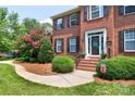 Elegant brick home with a beautifully landscaped yard, showcasing a classic front door and well-maintained surroundings at 10625 Olde Irongate Ln, Mint Hill, NC 28227