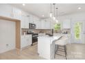 Bright kitchen featuring white cabinets, stainless steel appliances, and a stylish island with seating at 11032 Gary Player Dr # 961, Lancaster, SC 29720