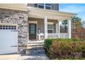 Inviting covered front porch with stone steps and columns, leading to a stylish front door at 111 Bell Chase Ln, Statesville, NC 28677