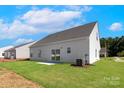 Spacious backyard featuring a well-manicured lawn, concrete patio, and a view of neighboring homes at 136 Adams Tree Way, Troutman, NC 28166