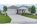 An inviting one-story home featuring a spacious driveway leading to an attached two-car garage with manicured lawn at 1819 Lotus Ln, Denver, NC 28037