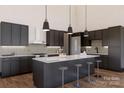 Modern kitchen featuring dark cabinetry, a large island with seating, and stainless steel appliances at 1935 Weddington Rd # 1, Matthews, NC 28104