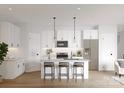 Modern white kitchen features a center island with seating, stainless steel appliances, and hardwood floors at 2004 Sadler Woods Ln, Charlotte, NC 28214