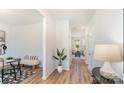 Hallway with wood floors, neutral walls, and a glimpse into a dining area, and a potted plant as decor at 4046 Jenison Valley Ct, Charlotte, NC 28214