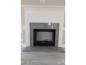 Close-up of the fireplace, featuring granite surround and hearth with a decorative white mantel and trim at 4166 Saltwood Dr, Hickory, NC 28602