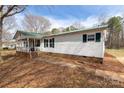 Ranch-style home featuring white horizontal siding, green metal roof, covered front porch, and minimal landscaping at 5212 Old Concord Rd, Salisbury, NC 28146