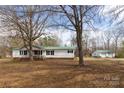 Cozy single-story home with a green metal roof, a detached garage, and a spacious front yard at 5212 Old Concord Rd, Salisbury, NC 28146