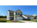 Two-story home featuring gray and tan siding, black shutters, and an attached two-car garage at 642 Lamorak Pl, Richburg, SC 29729