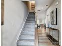 Bright foyer features wood flooring, a carpeted staircase, and stylish decor leading to the living areas at 8013 Downy Oak Ln, Charlotte, NC 28269