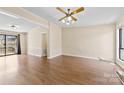 Bright living room featuring laminate wood floors, ceiling fan, and sliding glass door to the outside at 8123 Chrisbry Ln, Charlotte, NC 28215