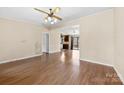 Open floor plan featuring laminate wood floors, ceiling fan, and dining room in background at 8123 Chrisbry Ln, Charlotte, NC 28215