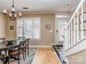 Inviting dining area with hardwood floors and natural light, adjacent to the home's staircase and entrance at 1141 Hollyheath Ln, Charlotte, NC 28209