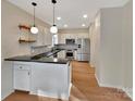 Modern kitchen with white cabinets, stainless steel appliances, and a dark countertop at 225 Howe St, Belmont, NC 28012