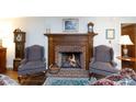 Living room featuring a cozy fireplace with a wooden mantel and hearth, flanked by two comfortable armchairs at 2622 Oakhurst Dr # 23, Rock Hill, SC 29730