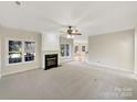 Spacious living room featuring a fireplace, large windows for natural light, and neutral carpeting at 2683 Beulah Church Rd, Matthews, NC 28104