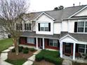 An aerial view of a townhome with brick and vinyl siding, a well-maintained lawn, and mature trees at 2856 Summergrove Ct, Matthews, NC 28105