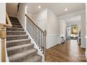 Open foyer showcasing wood flooring, classic wainscoting and a stairway to the second floor at 3193 Burnello Ct, Iron Station, NC 28080