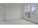 Bright, airy room with large windows, neutral carpet, and decorative molding at 561 Keystone Nw Ct, Concord, NC 28027