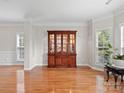 Elegant dining room featuring hardwood floors, neutral paint, a built in china cabinet, and large bright windows at 821 Lynnwood Farms Dr, Fort Mill, SC 29715