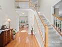 Bright foyer with hardwood floors, staircase, and views to the living area with fireplace at 821 Lynnwood Farms Dr, Fort Mill, SC 29715
