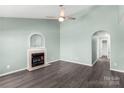 Bright living room featuring a cozy fireplace, ceiling fan, and hardwood floors at 8421 Kings Creek Dr, Charlotte, NC 28273