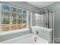 Bathtub and glass enclosed shower combination with window to exterior at 8421 Kings Creek Dr, Charlotte, NC 28273