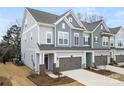 Desirable townhome showcasing a gray palette and front entry garage with well maintained landscaping at 9021 Charles Francis Ln, Cornelius, NC 28031