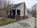 Side view of the home, highlighting the brick foundation, siding, and driveway leading to the garage at 927 Locke St, Salisbury, NC 28144