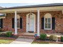 The front porch offers an inviting entrance with brick detailing, columns, and stylish outdoor lighting at 104 N Hawthorne St, Mount Holly, NC 28120
