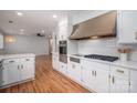 Modern kitchen with stainless hood vent, cooktop, oven, custom cabinets, and hardwood flooring at 104 N Hawthorne St, Mount Holly, NC 28120