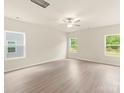 A sunlit room with neutral walls, modern vinyl flooring, and multiple windows framing green views at 108 Lightning Dr, Shelby, NC 28152