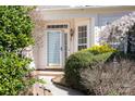 Close-up of the front door with sidelight windows, surrounded by lush greenery at 10829 Carmody Ct, Charlotte, NC 28277