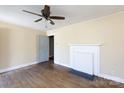 Bright living room features hardwood floors, a classic ceiling fan, and a decorative fireplace at 112 E Elliott St, Fort Mill, SC 29715