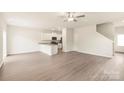 Open-concept living space with vinyl plank flooring, white walls and trim, and open kitchen at 119 Lightning Dr, Shelby, NC 28152