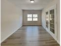 Bright living room with hardwood floors, large windows providing natural light and a door leading to the backyard at 13903 Glendevon Ct, Charlotte, NC 28273