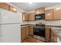 The kitchen features brown cabinets, a microwave, a stainless steel range, and a white refrigerator at 1606 Eagles Pl # J101, Rock Hill, SC 29732