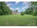 Expansive backyard with lush green grass and mature trees, offering a serene and private outdoor space at 16308 Poplar Tent Rd, Huntersville, NC 28078