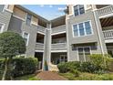 Stylish condo building with multiple balconies and gray horizontal siding surrounded by landscaping at 226 Queens Rd # 73, Charlotte, NC 28204